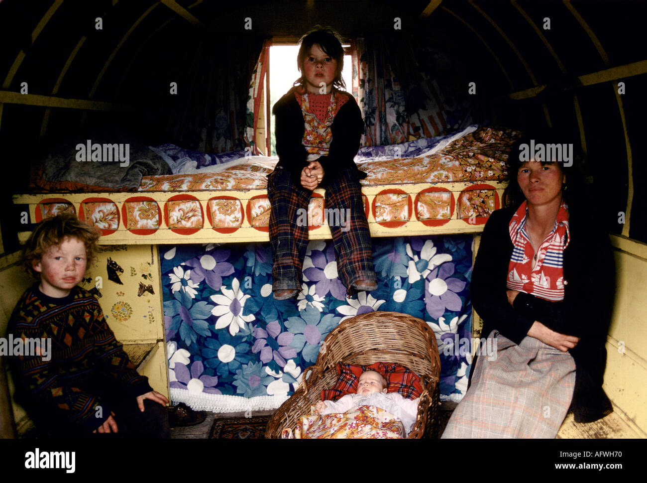 Irish Travellers gypsy family interior of painted decorated horse drawn bow topped caravan Ireland, mother, baby and sons 1970s 1979 Eire. HOMER SYKES Stock Photo