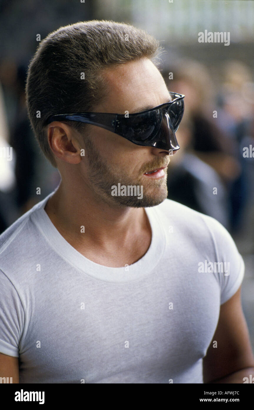 1980s UK fashion, man wearing statement dark plastic sunglasses with nose shield and white T shirt  London England. HOMER SYKES Stock Photo