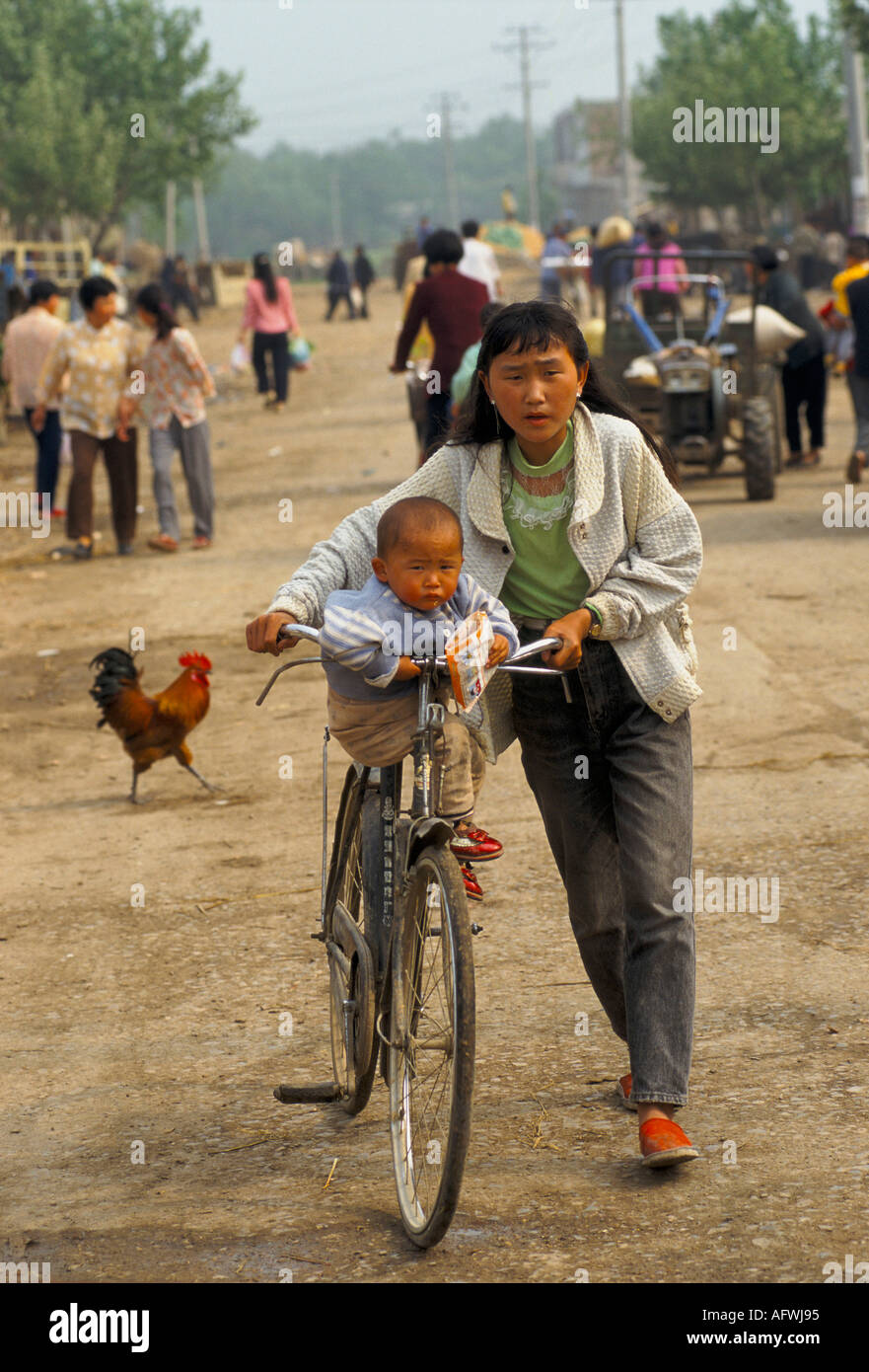 China Anhui Province 1990s rural community, mother with child of bike Chinese one child policy. 1998 HOMER SYKES Stock Photo