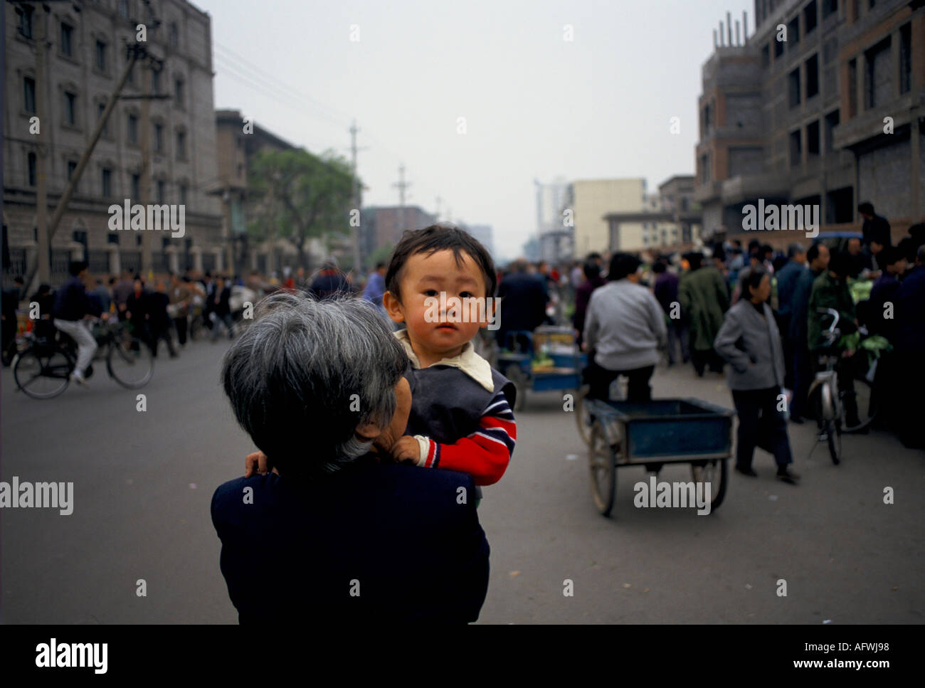 Beijing China 1998. Mother and son daily life. Child being carried through the street  by his Mom. Government One Child Policy. HOMER SYKES Stock Photo