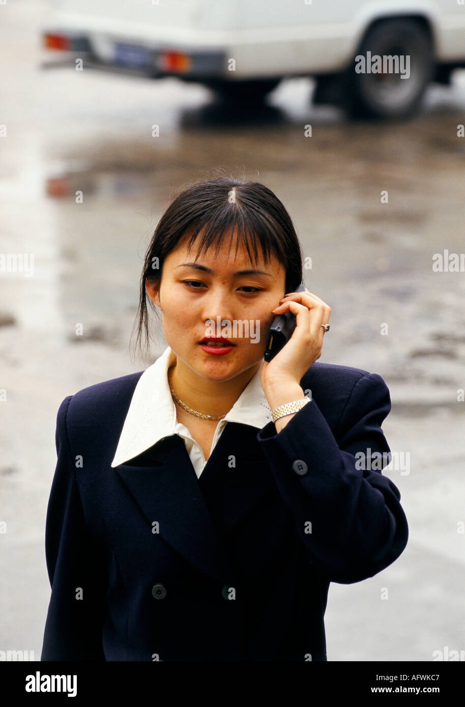 China 1990s Woman using old fashioned retro  mobile phone, making a phone call Beijing  1998 .HOMER SYKES Stock Photo