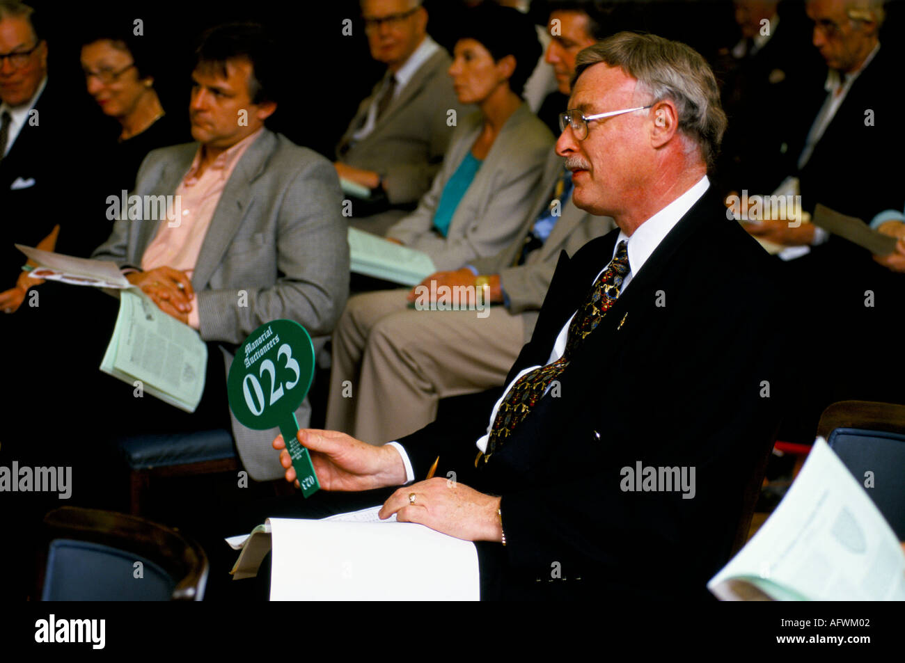Auction London 1990s Uk. People attend Manorial Auctions, Lord of the Manor title deeds being auctioned man holding 'paddle' with number HOMER SYKES Stock Photo