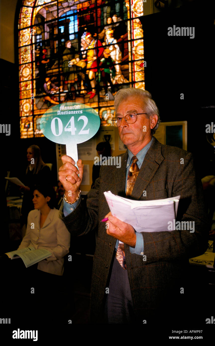 Auction 1990s UK. Manorial Auctions man bidding using a numbered  auction paddle buying Lord of the Manor title deeds. HOMER SYKES Stock Photo