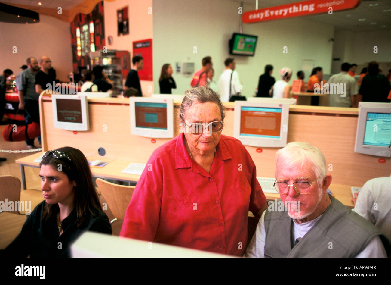 World Wide Web Internet cafe London UK 1990s. Elderly couple using computers, customers background queue up for cafe service. 1999 England HOMER SYKES Stock Photo