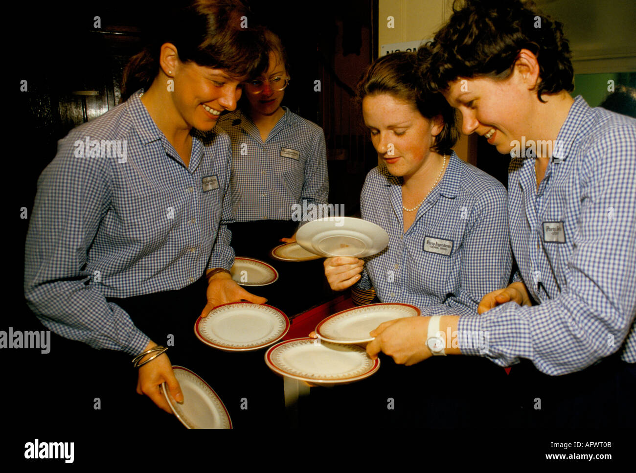 Part time casual employees working catering staff Fishmongers Hall City of London. Before banquet new girls are being shown how to hold plates. 1992 Stock Photo