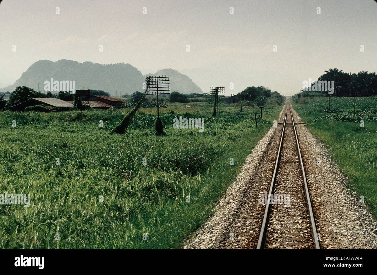 Train journey through Malaysia. Single line  track cuts rural landscape. South East Asia.1991 1990S HOMER SYKES Stock Photo