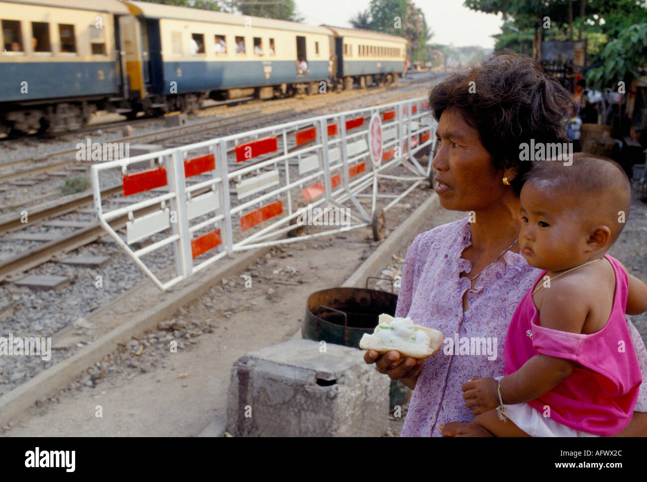 Slums people living in poverty along the  railway line outside Bangkok main railway train station  mother and child. Thailand 1990s  HOMER SYKES Stock Photo