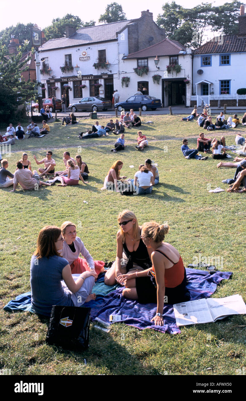 A summer drink Wimbledon Common group friends sitting on lawns outside the Crooked Billet pub. SW19 London pubs.  UK 2000s 2001 HOMER SYKES Stock Photo
