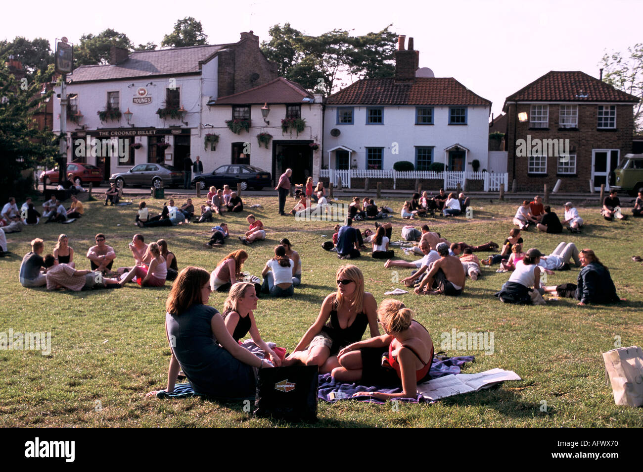 London pubs. A summer drink Wimbledon Common pub group friends sitting on lawns outside the Crooked Billet London SW19 UK 2000s 2001 HOMER SYKES Stock Photo