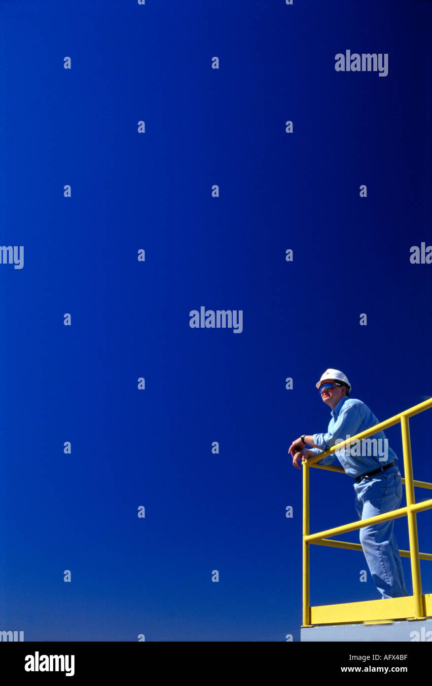 construction worker at railing at industrail plant Stock Photo