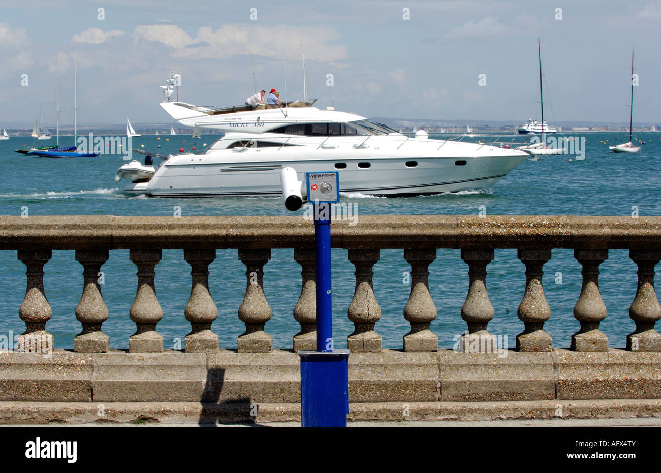 large motor yacht power boat cruiser passing the sea wall at cowes parade esplanade on the isle of wight Stock Photo