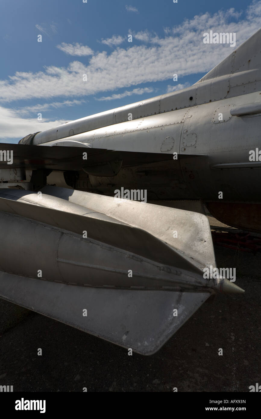 Under wing ordnance on parked MiG-21 aircraft shot against sunny sky Stock Photo