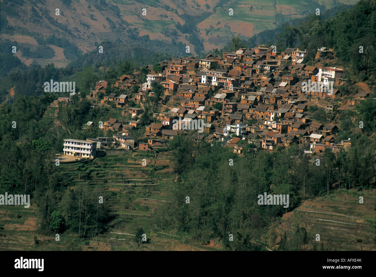 A mountain village rests atop terraced hills. Stock Photo