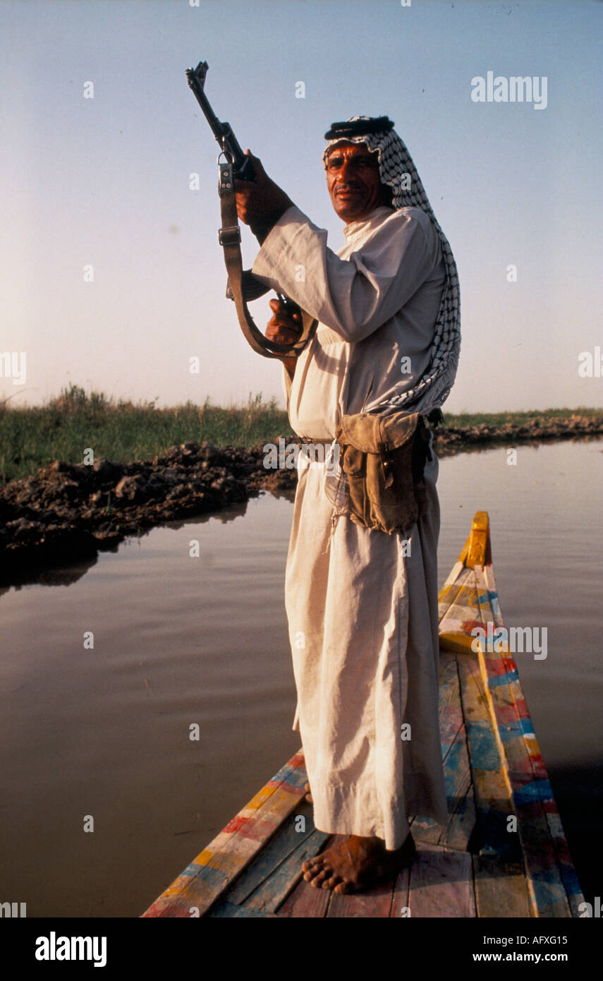 arsh rab fighter with rifle standing in his boat evening patrol. 1984. Near Basra Southern Iraq 1980s Homer Sykes Stock Photo