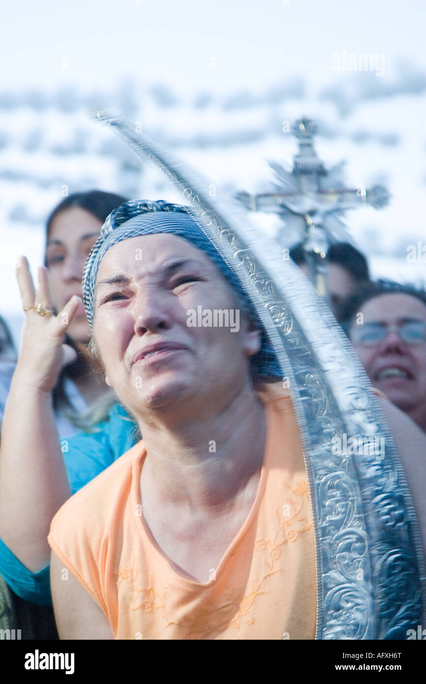 Moved women carrying Virgin holy valuables as vow praise Virgin image and cry Stock Photo