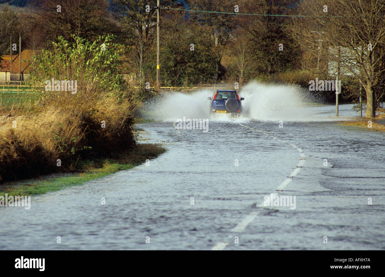 LAVANT WEST SUSSEX England UK November A car is driving along a flooded road after the River burst its banks Stock Photo