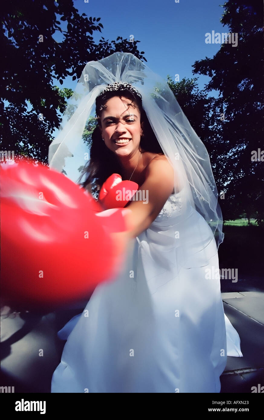 Bride takes a swing wearing boxing gloves Stock Photo