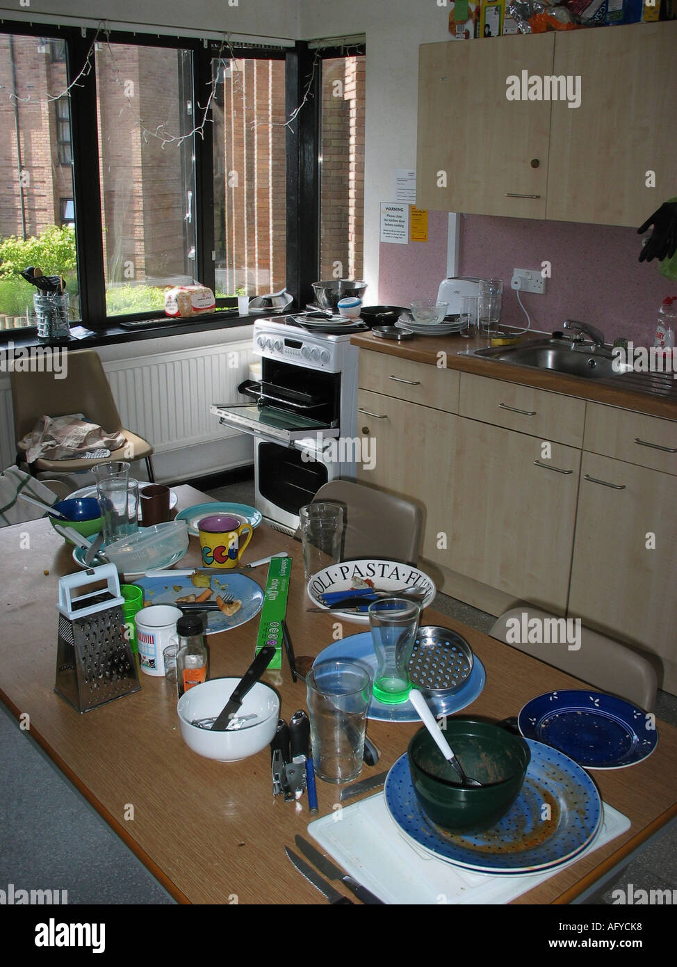 Table in Kitchen of Student Flat with dirty dishes left out Stock Photo