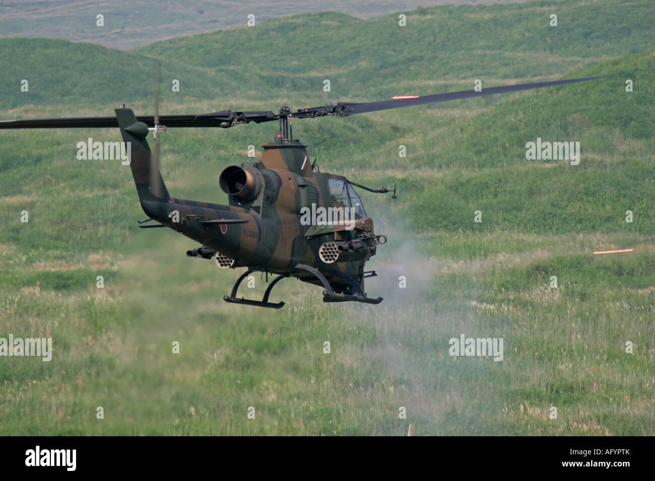 Japan Ground Self Defence Force AH-1 Cobra helicopter firing 20mm machine gun Stock Photo
