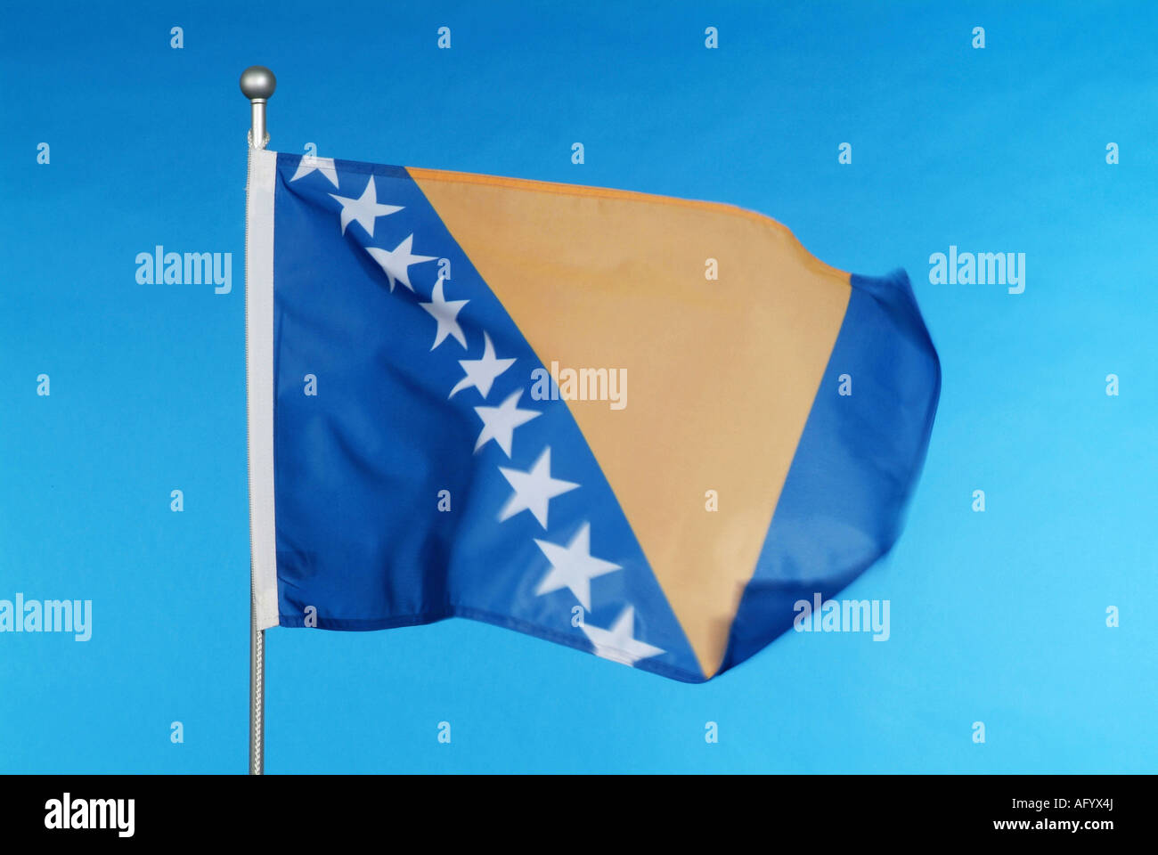 National flag of Bosnia and Herzegovina against blue sky Stock Photo
