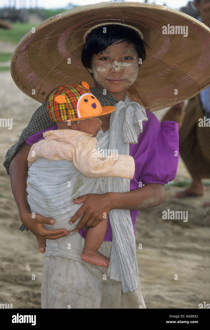 Young girl with tanaka bark past on face cares for her younger brother in Burma/Myanmar Stock Photo