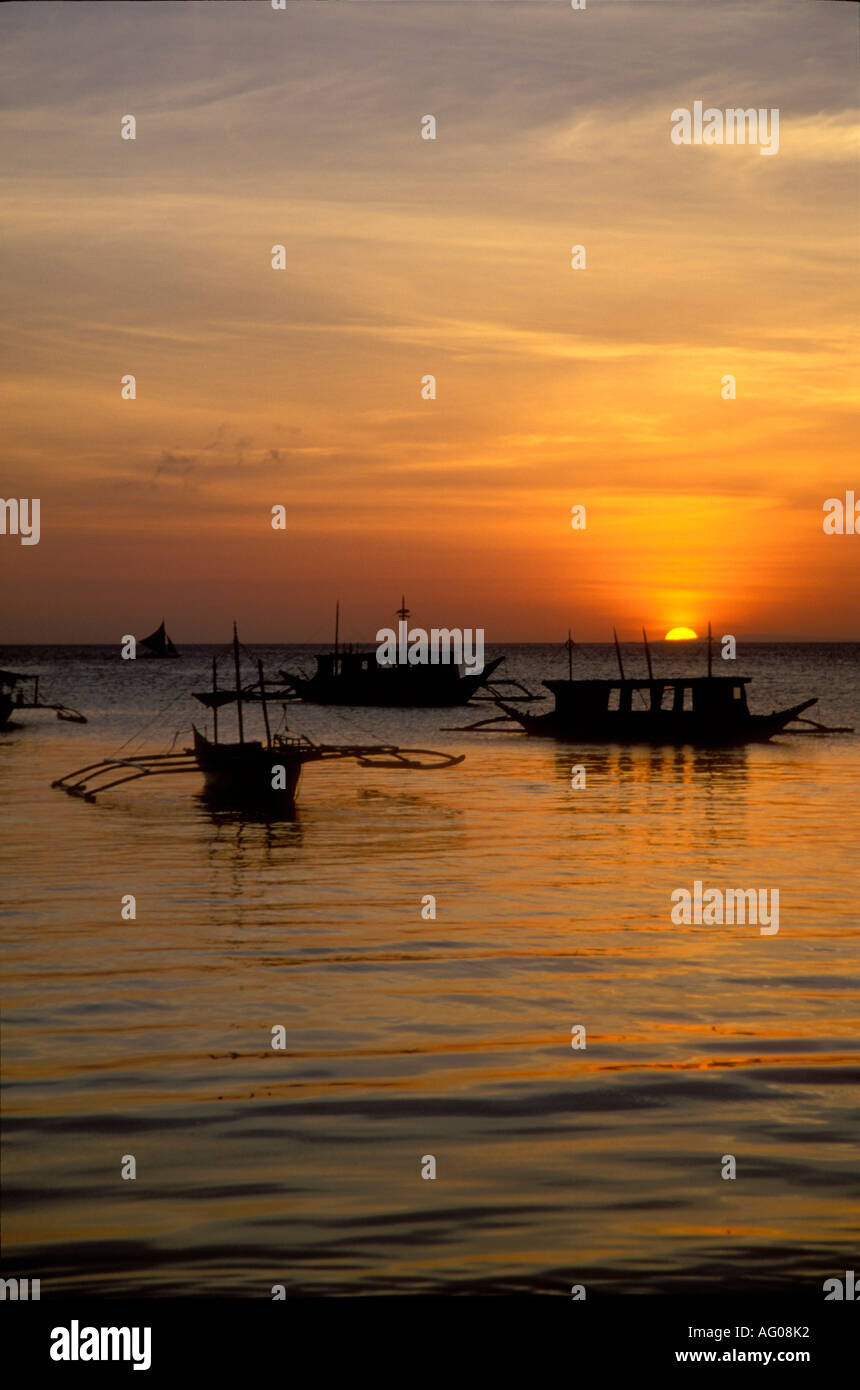 Sun setting on horizon and floating boats , Boracay , Philippines Stock