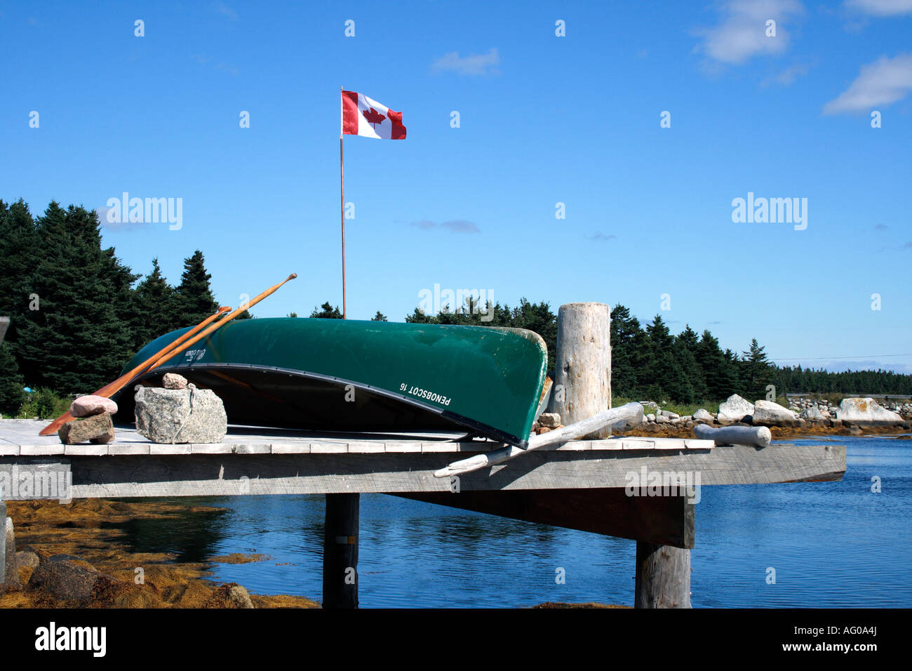 jetty upside down Old Town canoe, paddle and Canadian  Maple Leaf Flag, Nova Scotia, Atlantic Canada. Photo by Willy Matheisl Stock Photo