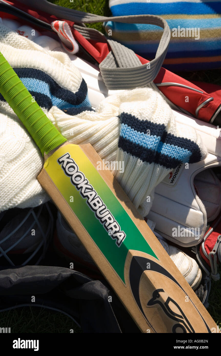 A set of cricket equipment in kit bag at match summer afternoon - bat pads jumper Stock Photo