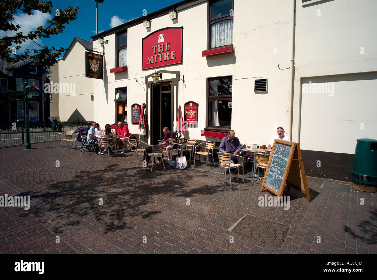 People sitting outside and drinking in the sunshine The Mitre pub Pwllheli Gwynedd north wales Stock Photo