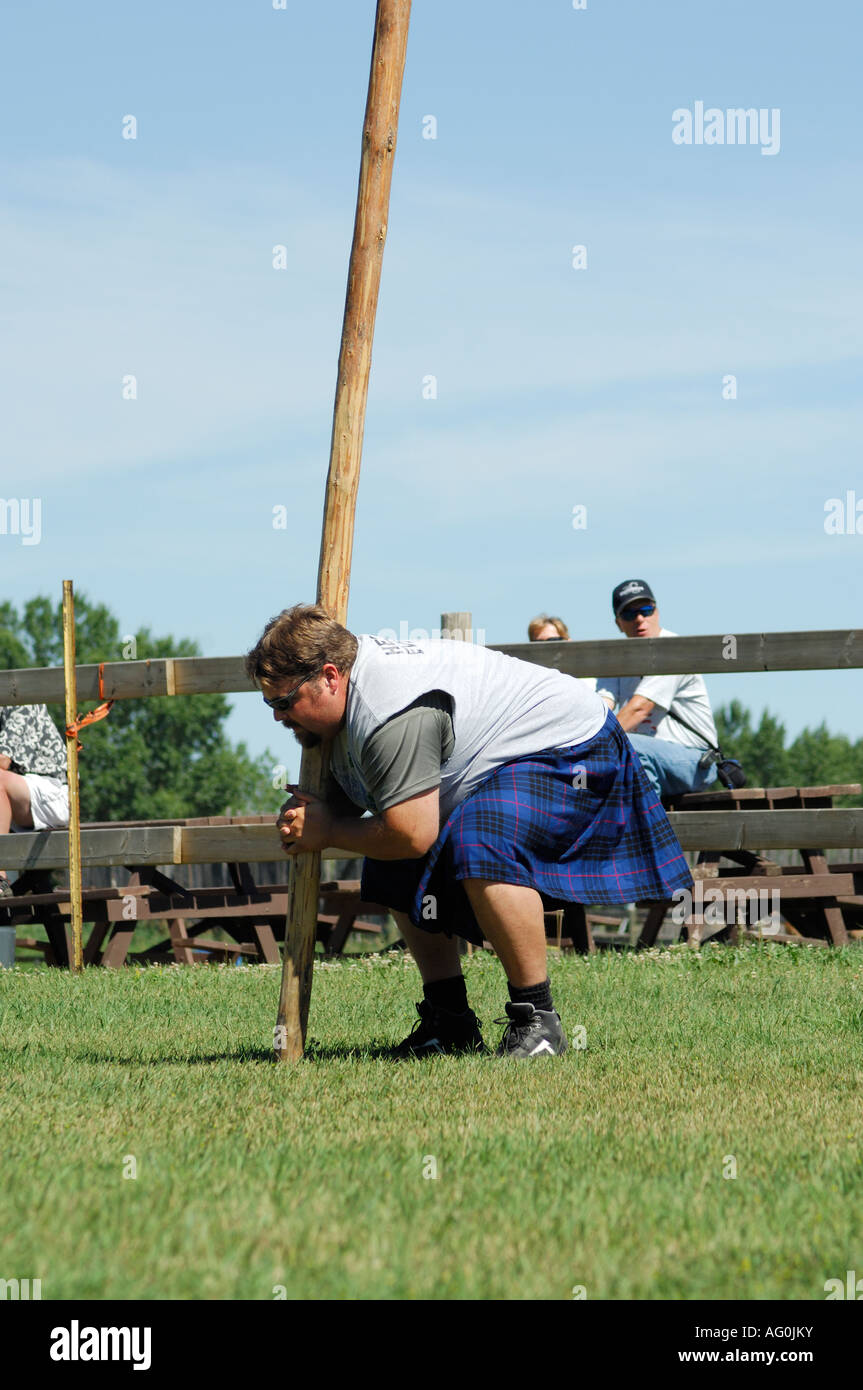 Man getting to toss "the caber" at a Highland Games gathering Stock