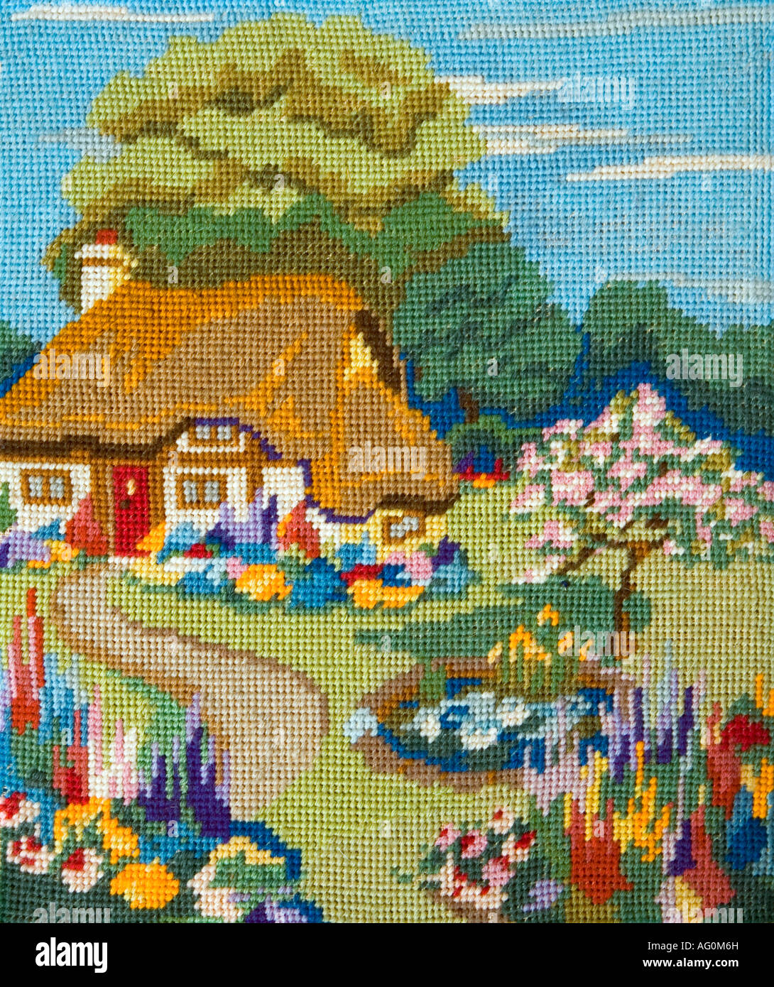 Embroidered idyllic country cottage with a vibrant garden Stock Photo