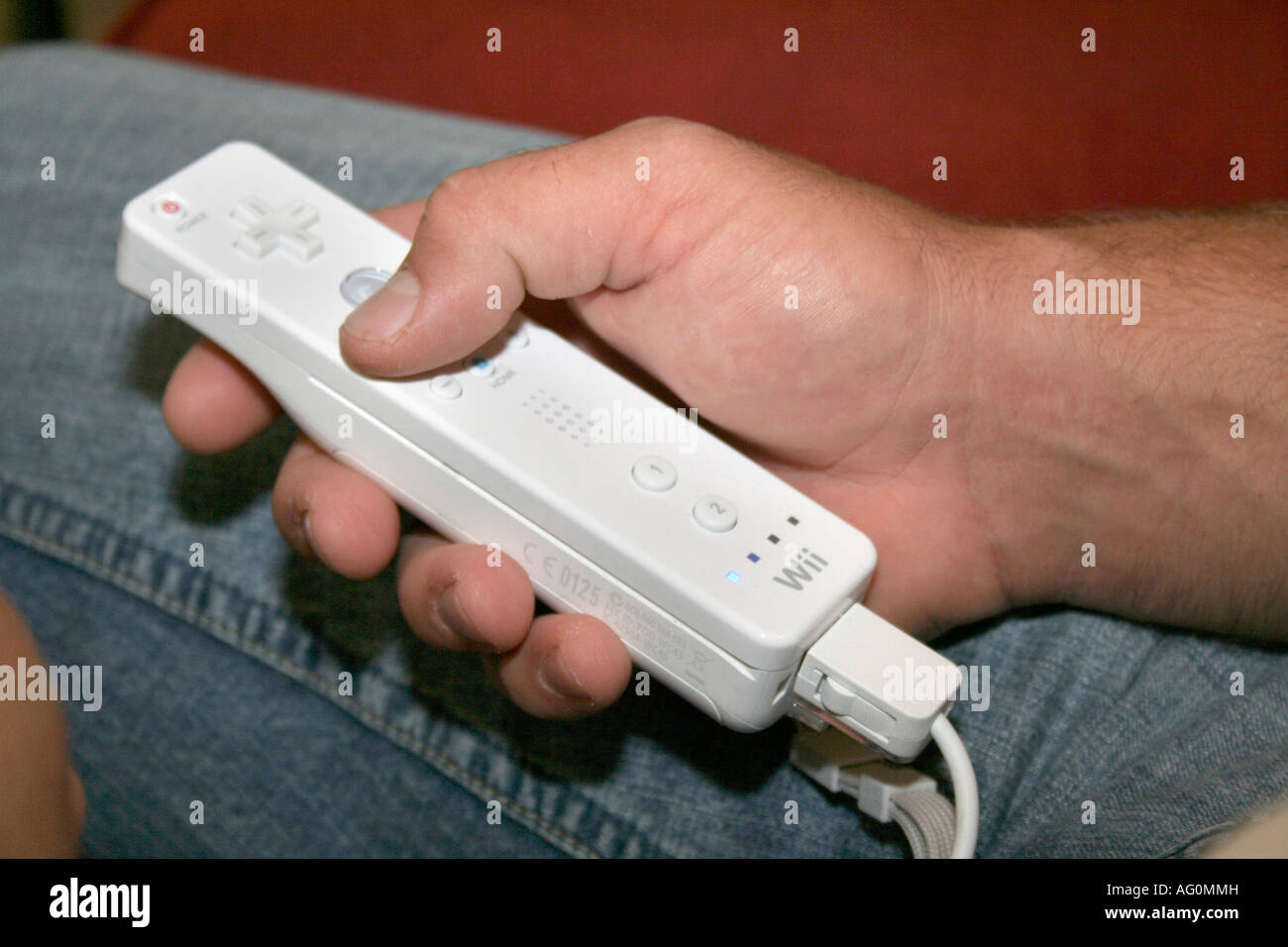 male hands holding Nintendo Wii remote control Stock Photo
