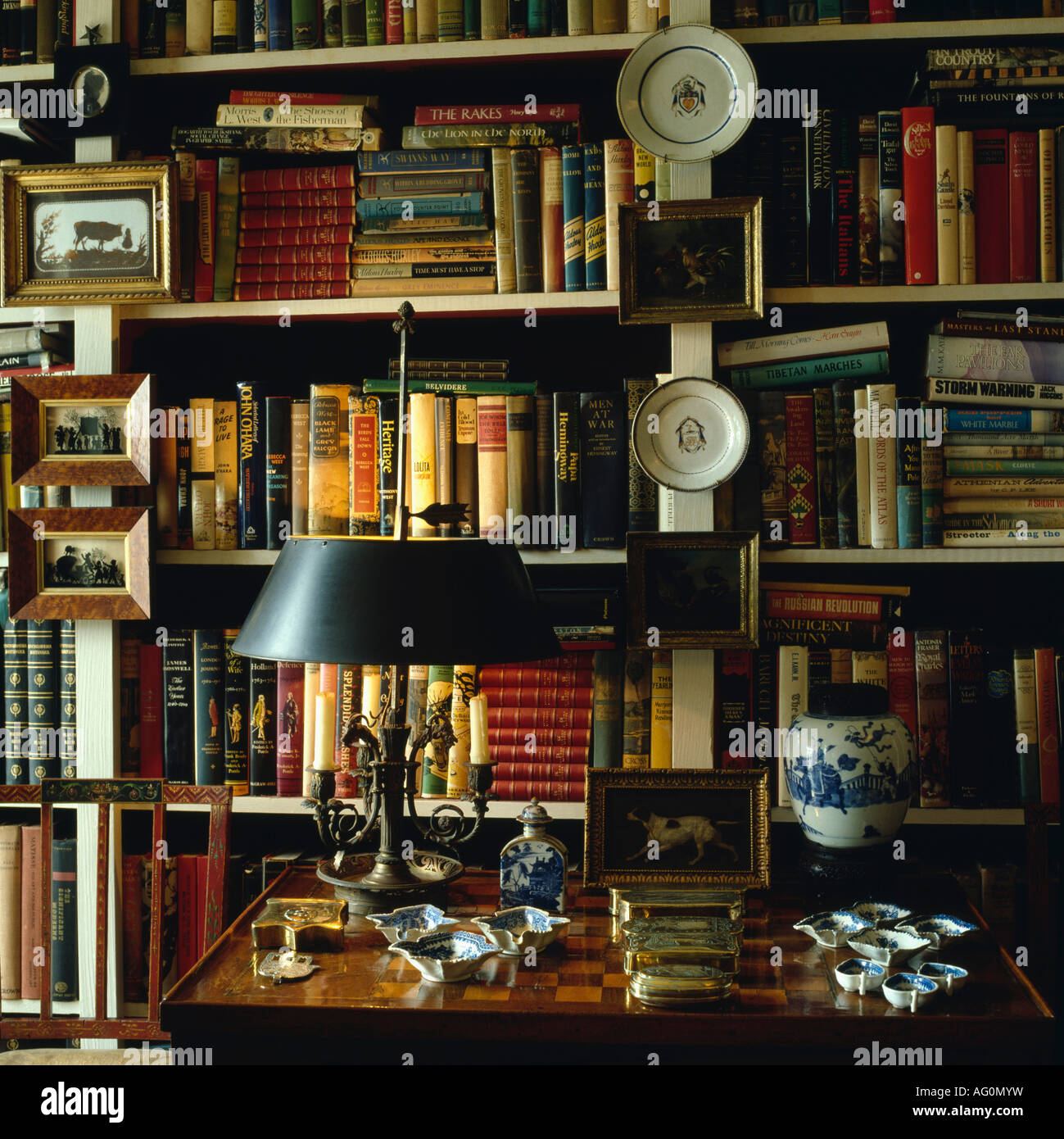 Black lamp on desk in front of bookshelves Stock Photo Alamy