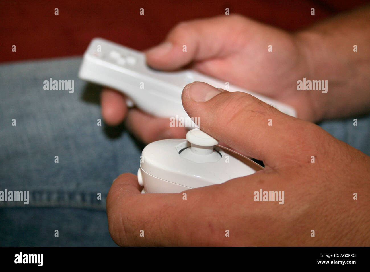 male hand holding Nintendo Wii remote control Stock Photo