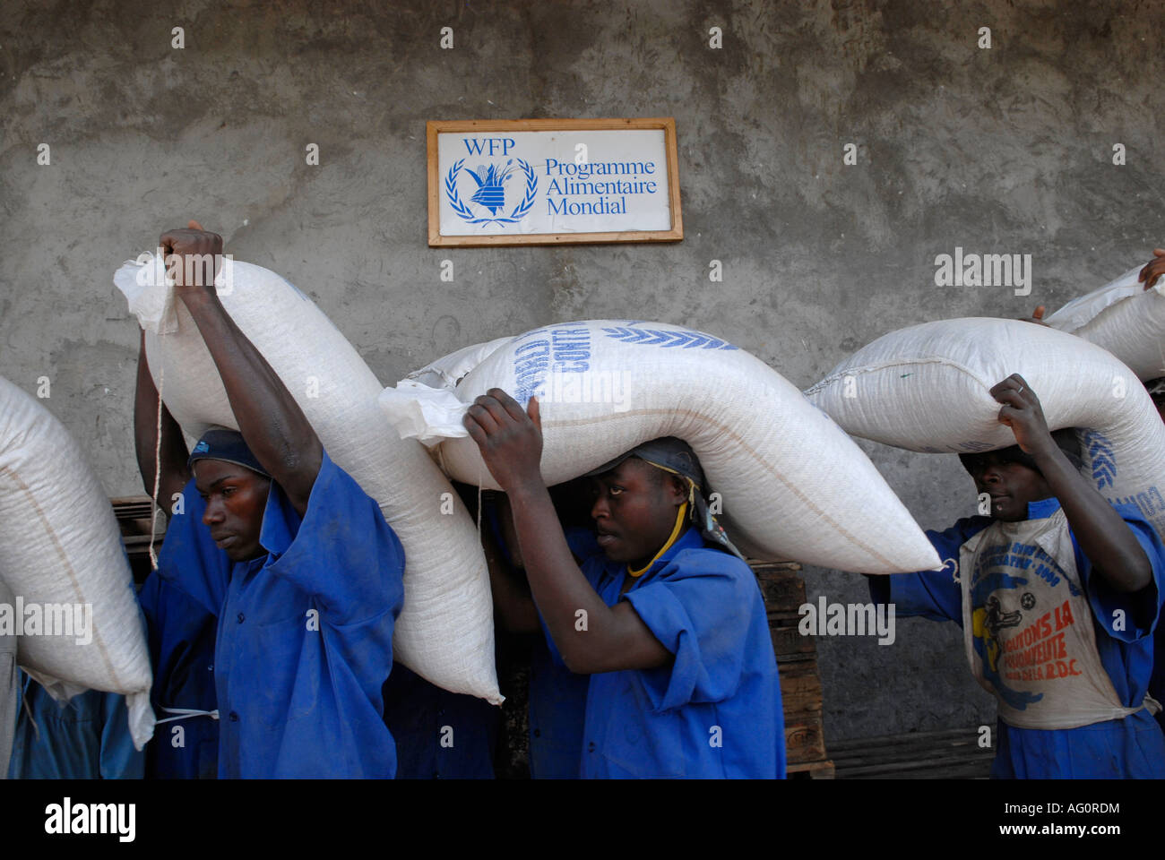 Men carrying sacks of maize during food distribution carried out by the