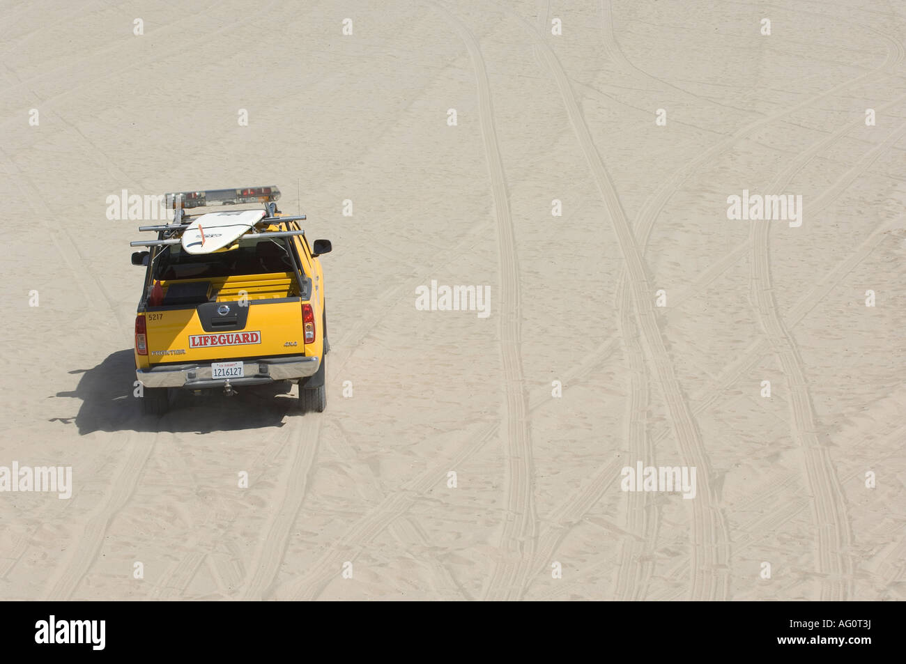 Lifeguard truck drives along California's white sand beaches. Stock Photo