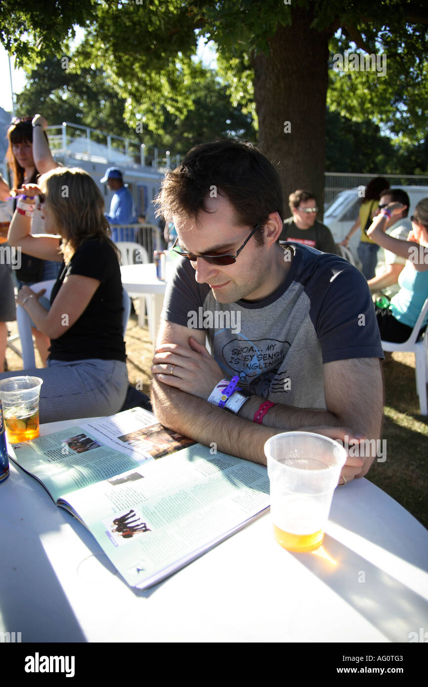 Man reading programme at Guilfest music festival. Guildford, Surrey, England Stock Photo