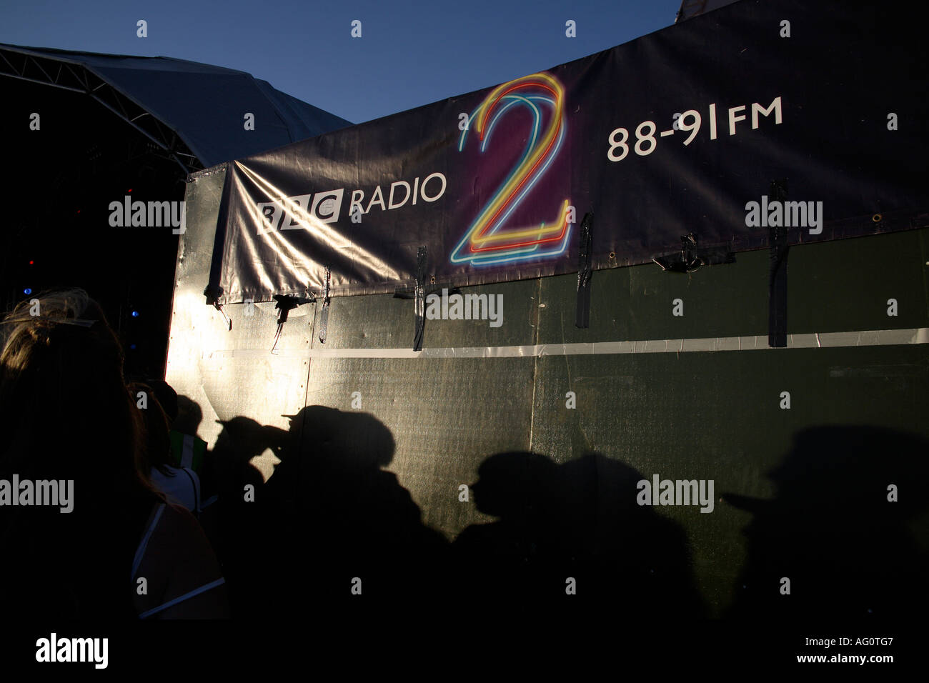 Shadows of audience at Guilfest Music Festival on  BBC Radio 2 banner. Guildford, Surrey, England Stock Photo