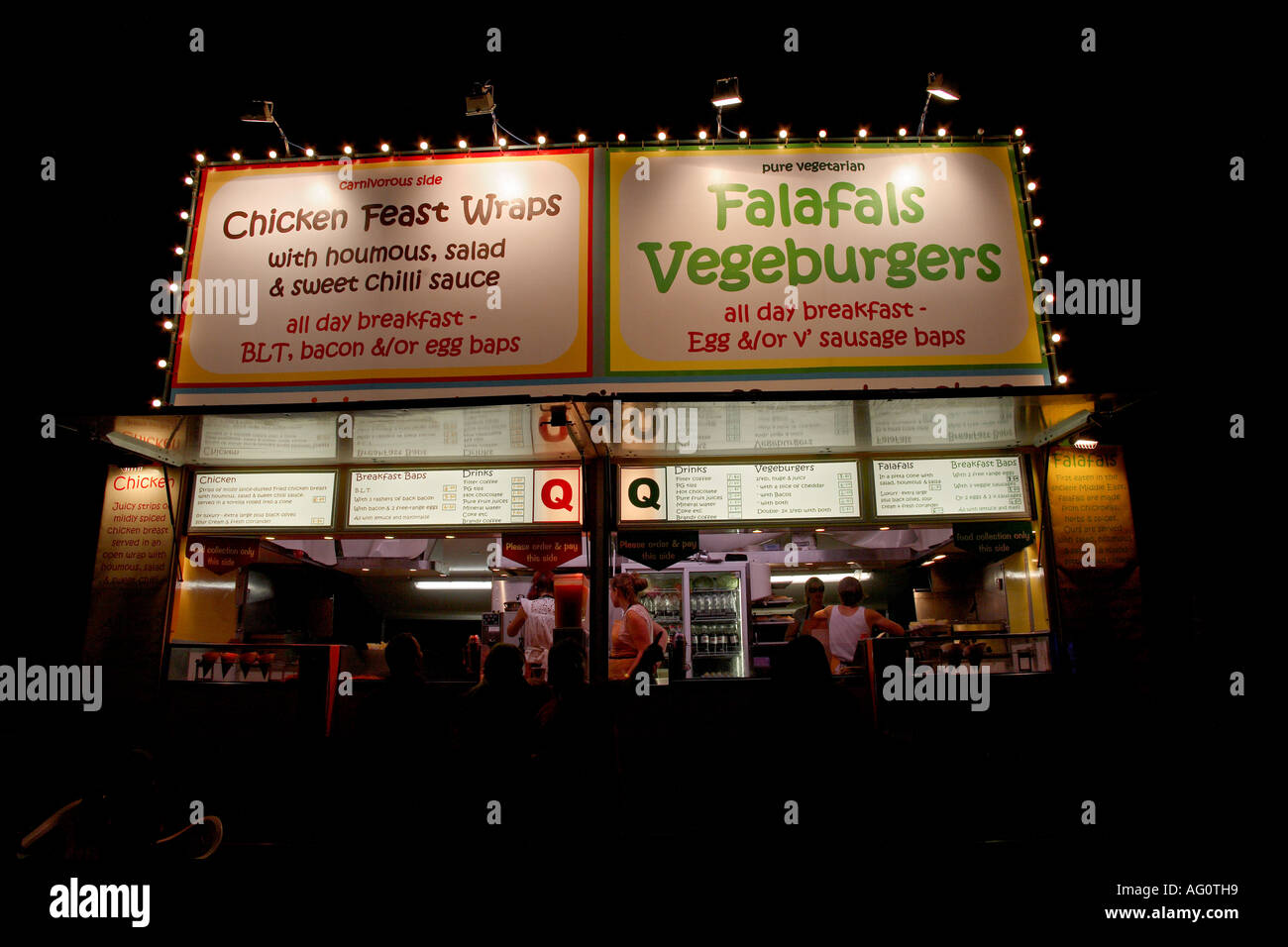 Chicken, falafal and vegeburger stall at night. Guilfest music festival, Guildford, Surrey, England Stock Photo