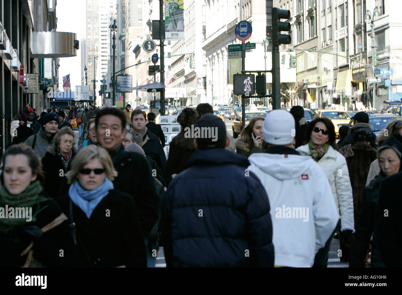 mixed race pedestrians walk up a busy sidewalk in a street on fifth avenue new york city new york USA Stock Photo