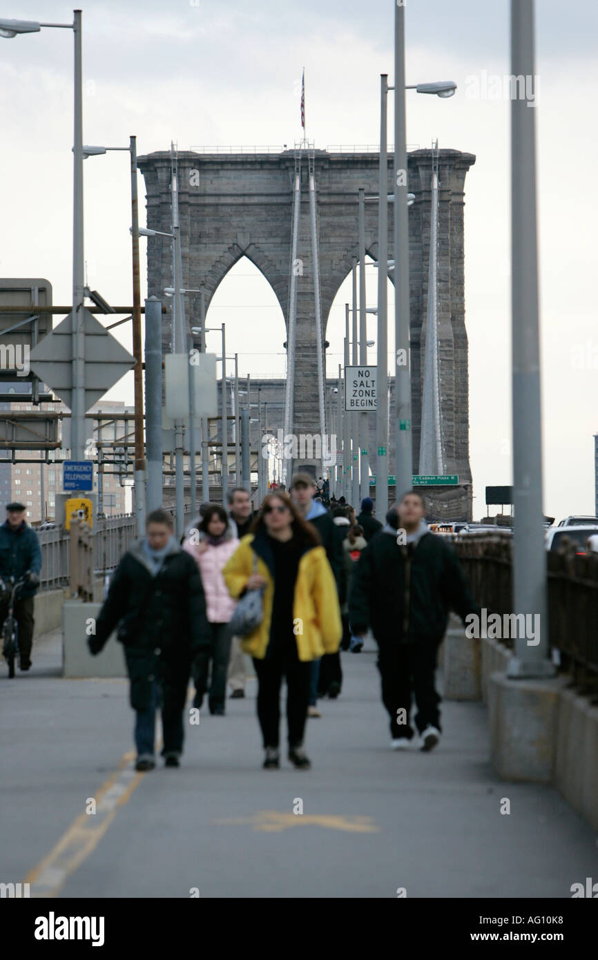people walking across the brooklyn bridge new york city new york USA