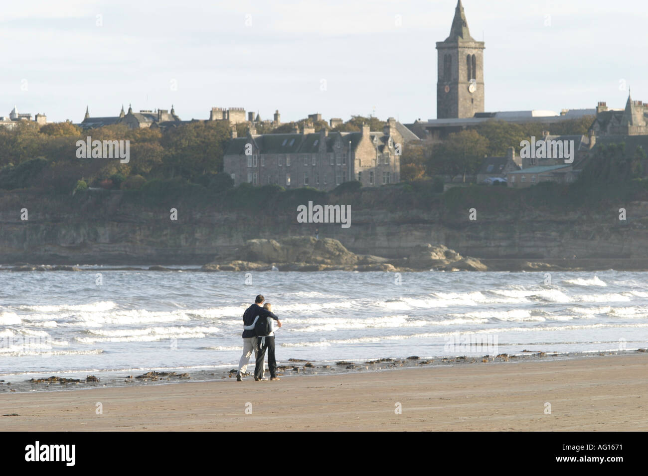 Students at St Andrews University Fife Scotland walk along the beach Stock Photo