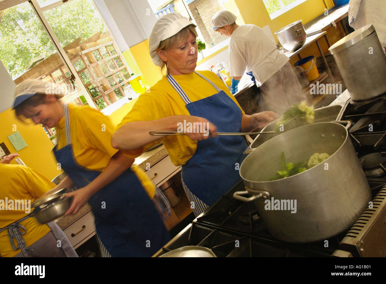 Cooking healthy school dinners with fresh produce in a Gloucestershire school kitchen Stock Photo