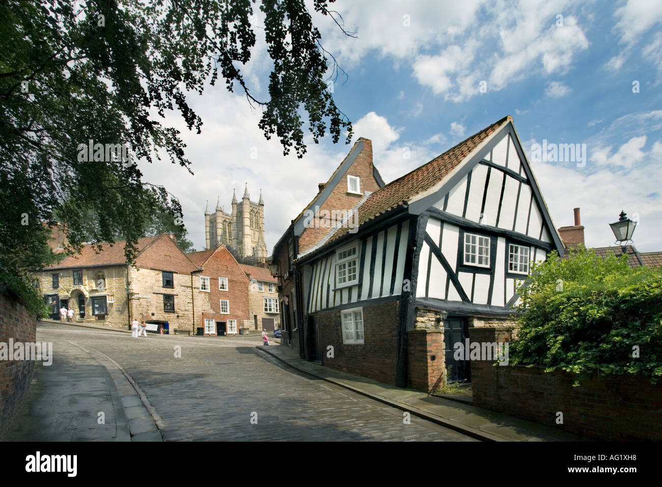 STEEP HILL LINCOLN IN JULY. THIS IS THE CROOKED HOUSE, A 16 TH CENTURY HALF  TIMBERED HOUSE AT THE TOP OF MICHAELGATE. Stock Photo