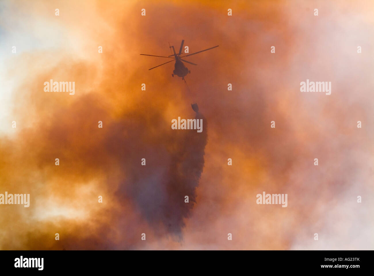Helicpoters fighting a mountain fire using water bombs Flying into and