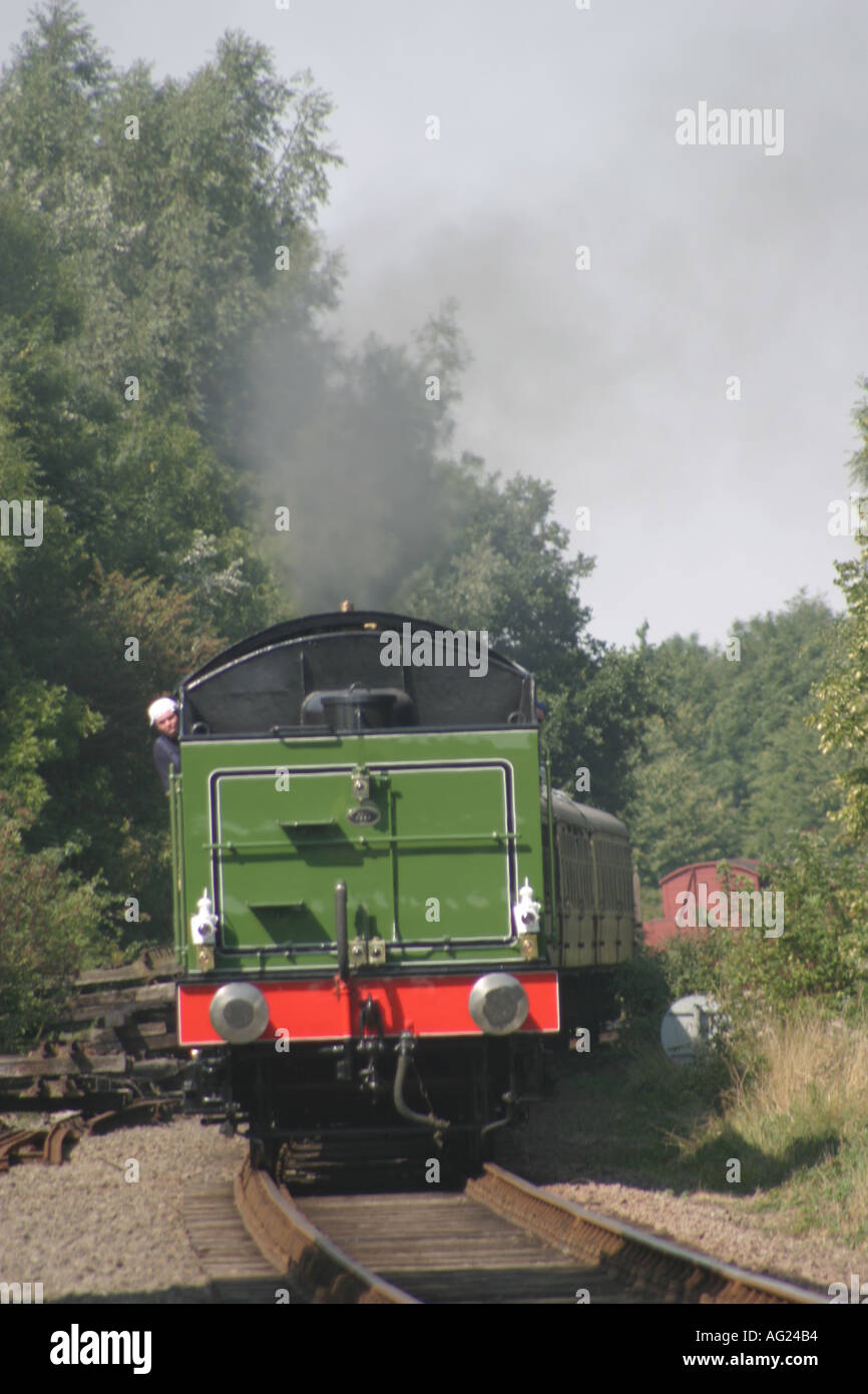 Train Reverse Steam train reversing on track with driver looking out of cab, with ...