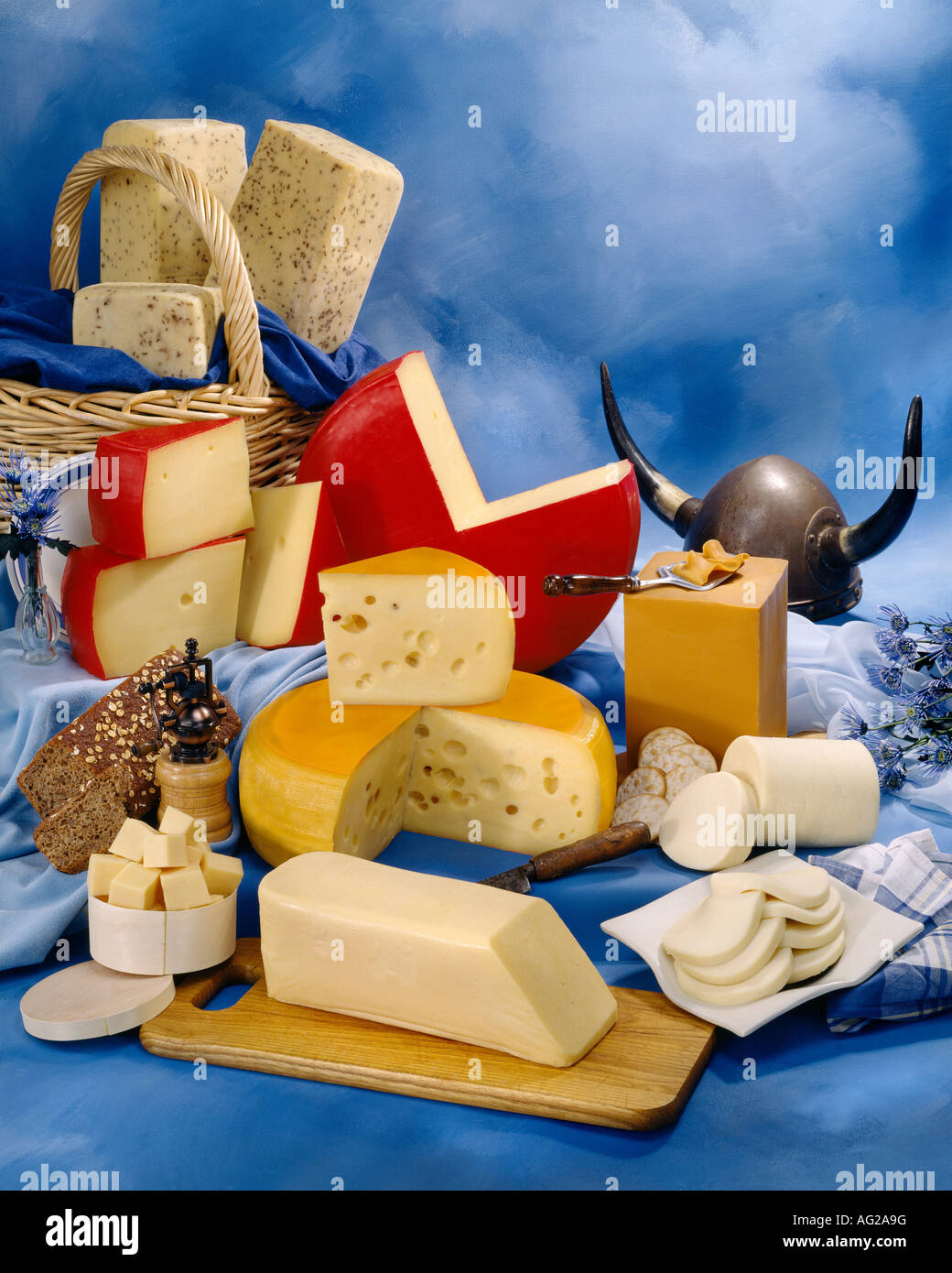 Scandinavian Cheeses in group color photograph on blue toned mottled background. Vertical Format, studio tabletop. Classic Image Stock Photo