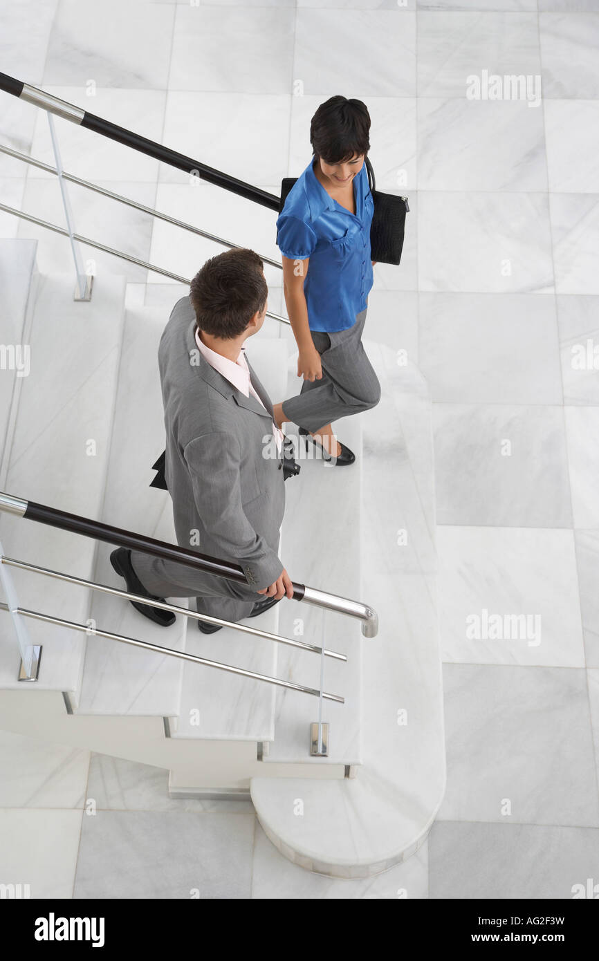 Two business people walking down stairs Stock Photo - Alamy