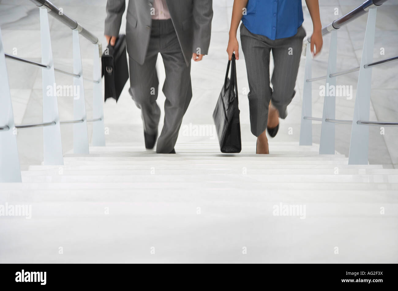 Two business people walking up stairs Stock Photo - Alamy