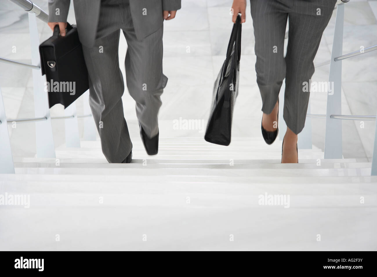 Two business people walking up stairs Stock Photo - Alamy